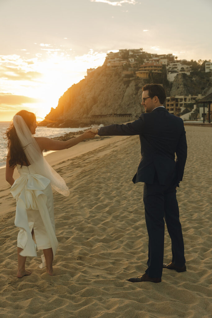 couple walks on beach at Mexico sunset destination wedding