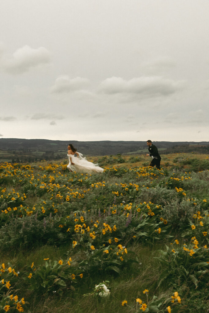 couple runs through wildflower field at outdoor elopement