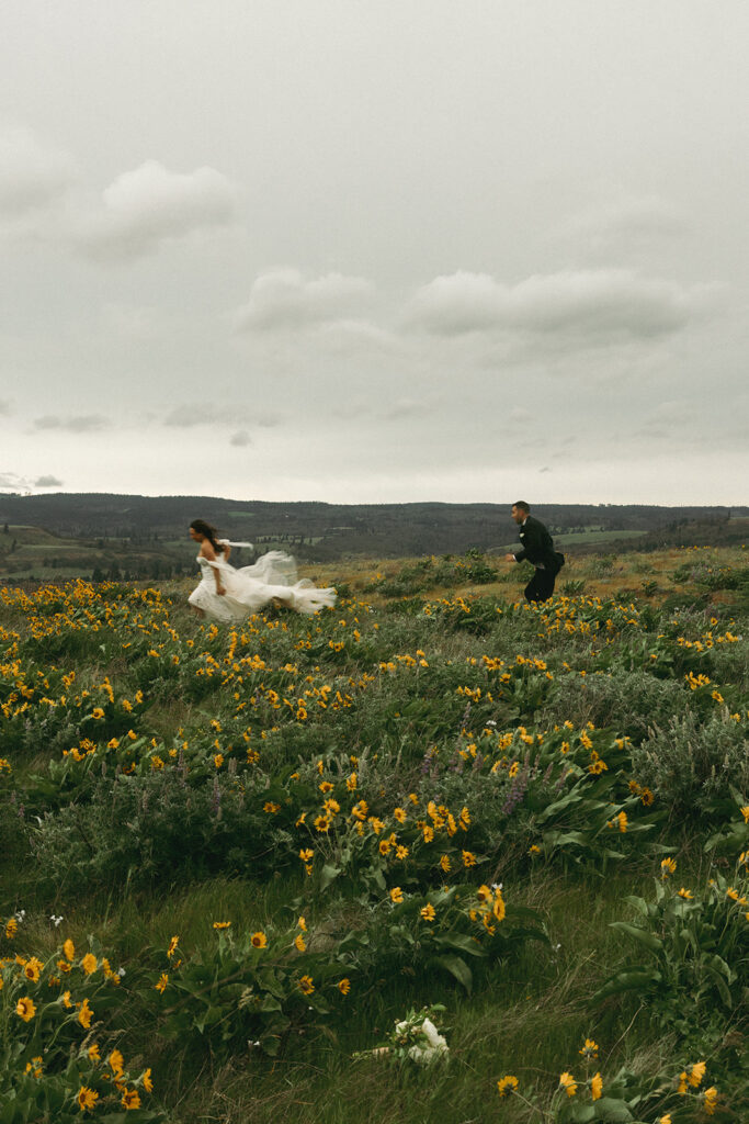 couple runs through wildflower field at outdoor elopement