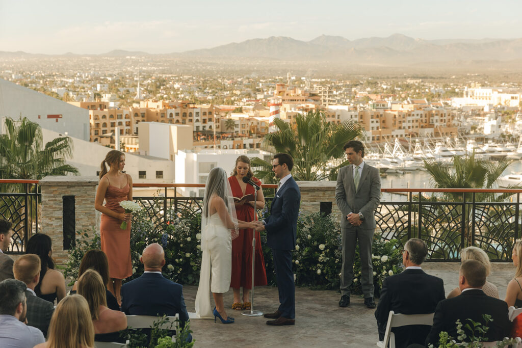 couple exchanges vows at spot overlooking city at Mexico wedding