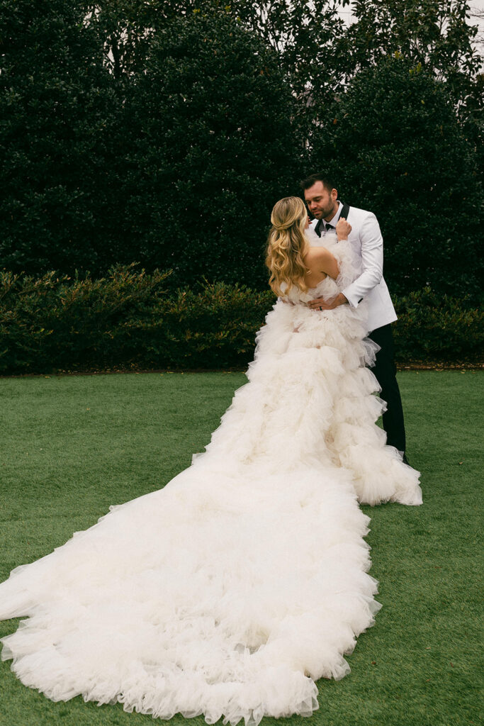 couple embraces with long wedding dress at Raleigh North Carolina wedding venues