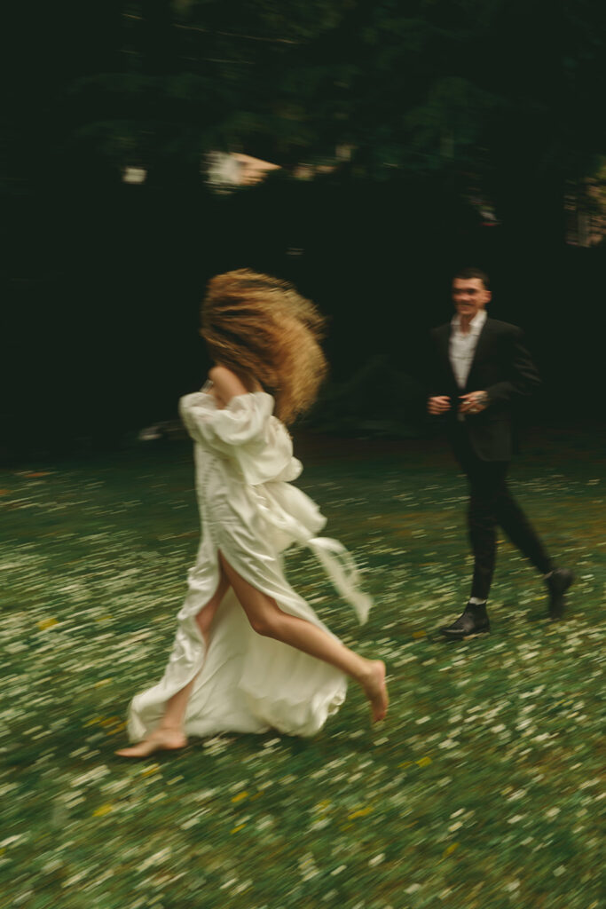 couple runs together through flowery field