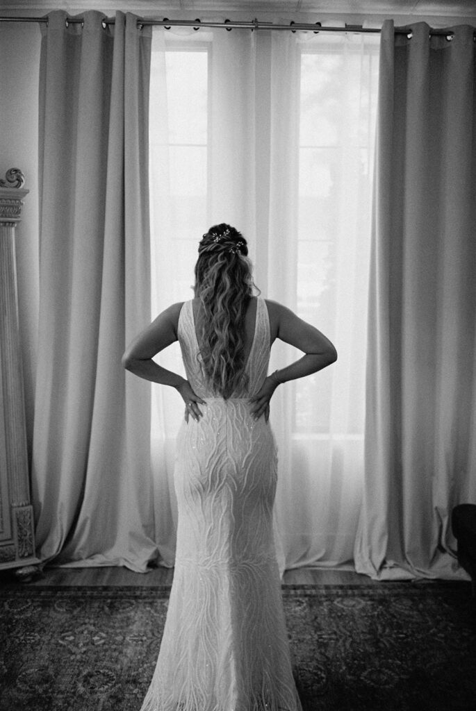 bride stands in front of tall window at Raleigh North Carolina wedding venues