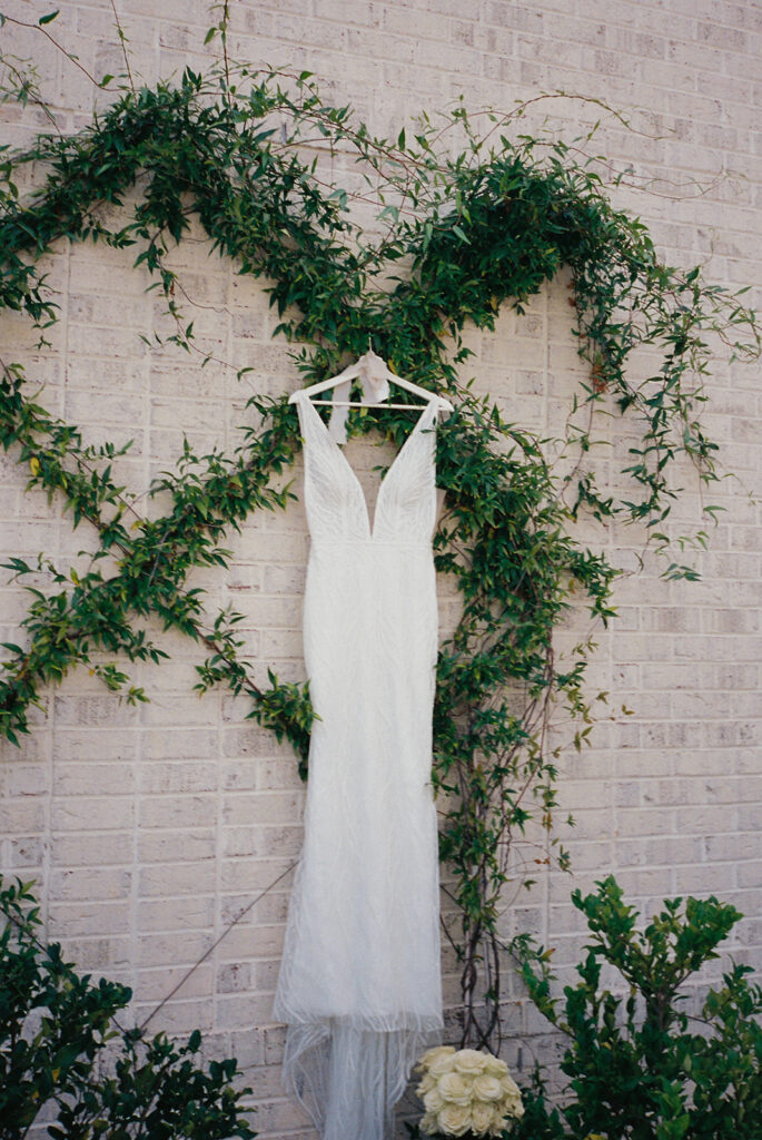 wedding dress hangs on ivy-covered wall at Raleigh North Carolina wedding venues