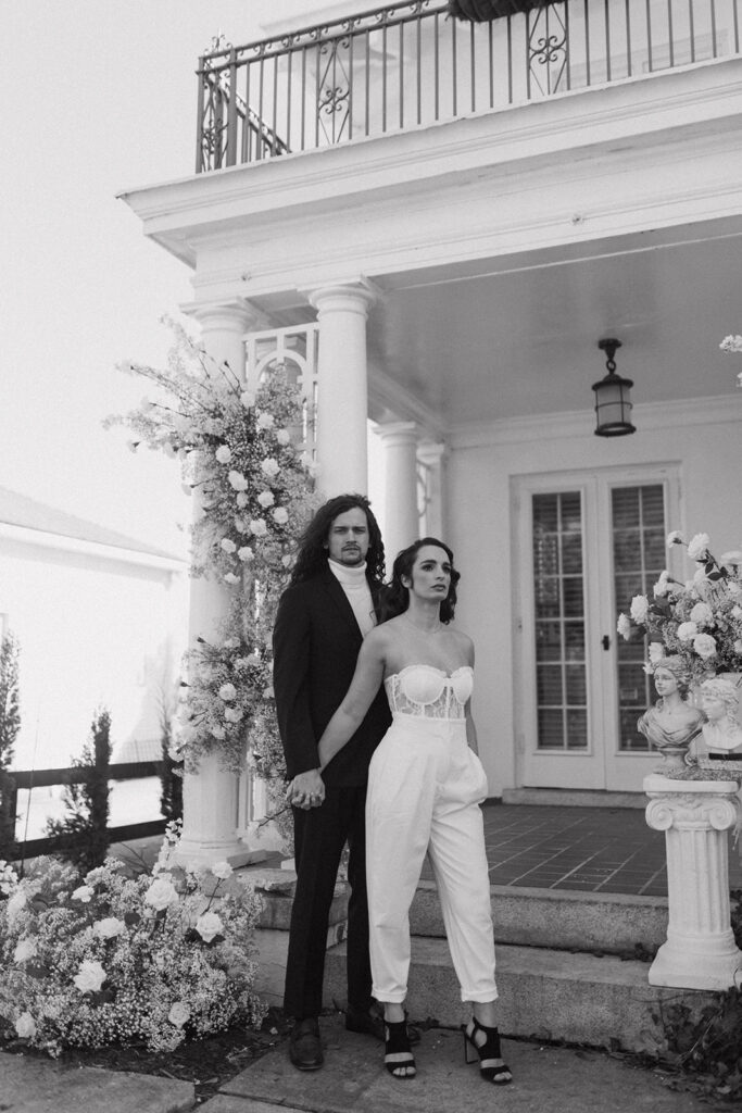 couple holds hands in front of house at Raleigh North Carolina wedding venues