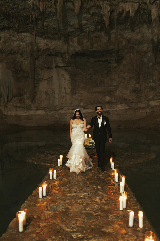 wedding couple walks along candlelit path