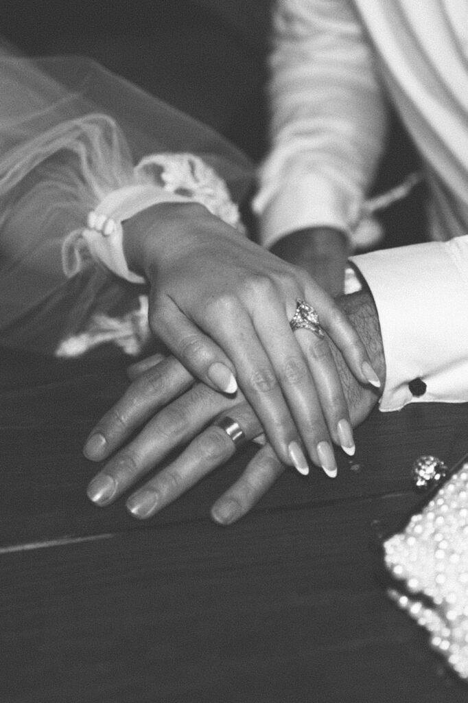 traveling photographers take artistic shot of couple's hands at wedding