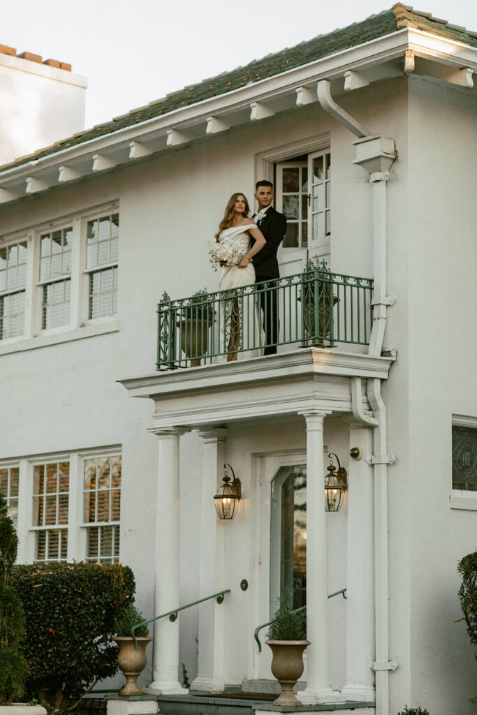 couple stands on porch at Raleigh North Carolina wedding venues