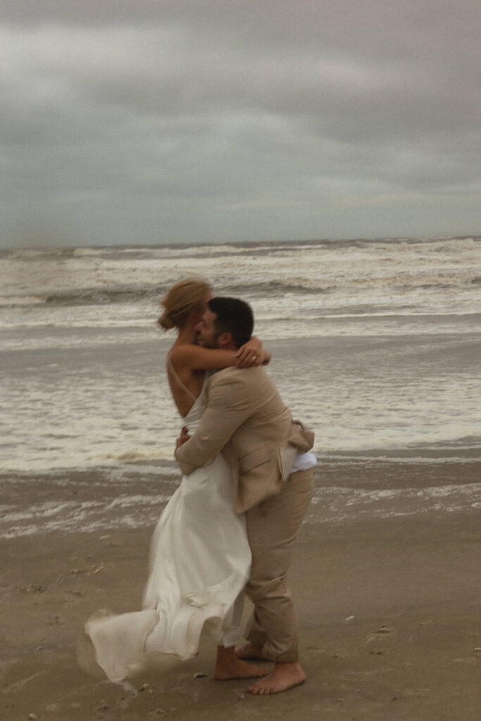 couple embraces on sunset beach standing in water