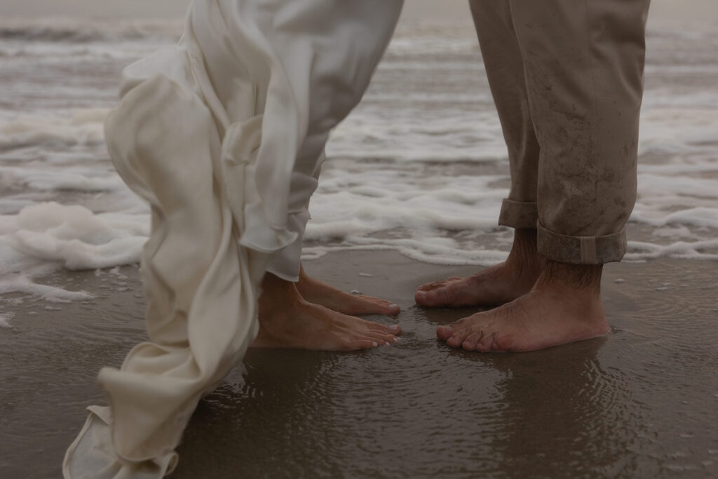 wedding couple's feet standing in ocean water