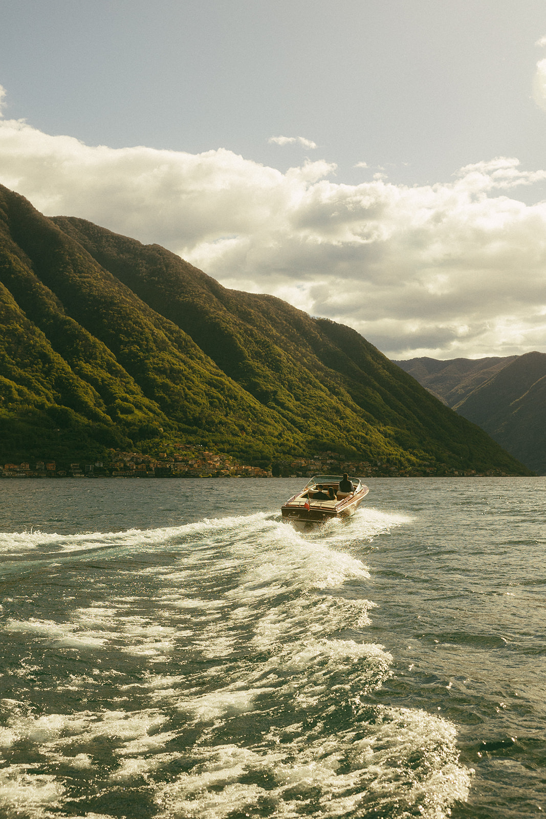 lake como italy wedding couple rides in boat