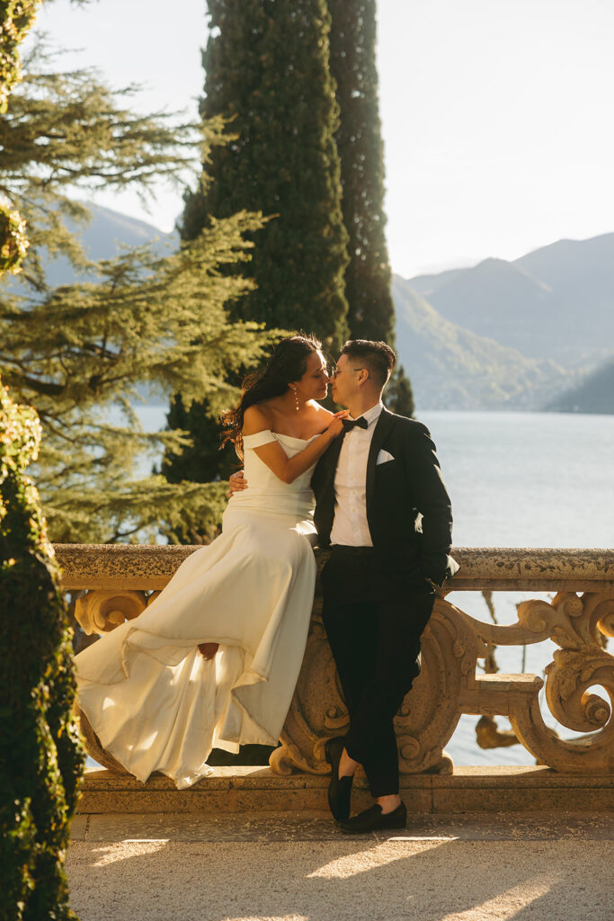 couple kisses leaning on railing at Italy Lake Como wedding 