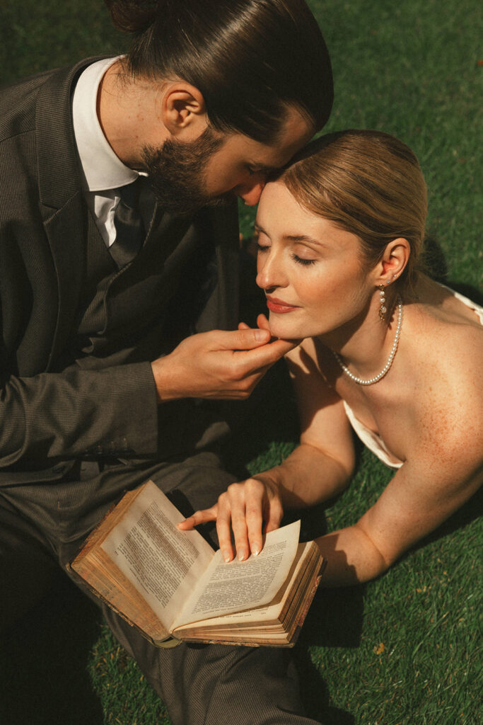 couple lies in grass reading book