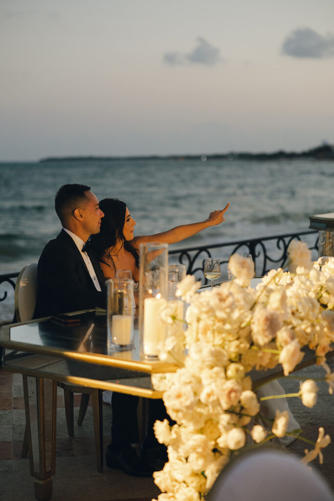 couple sits at candlelit wedding reception table