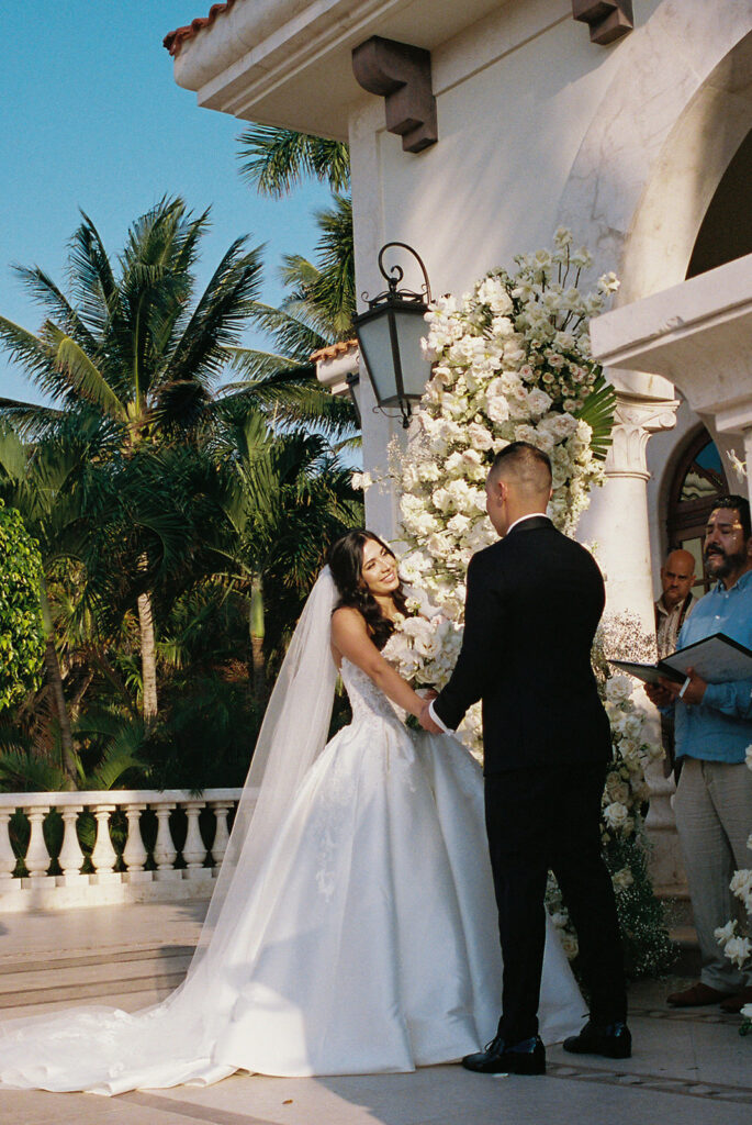 couple exchanges vows at wedding ceremony under palm trees