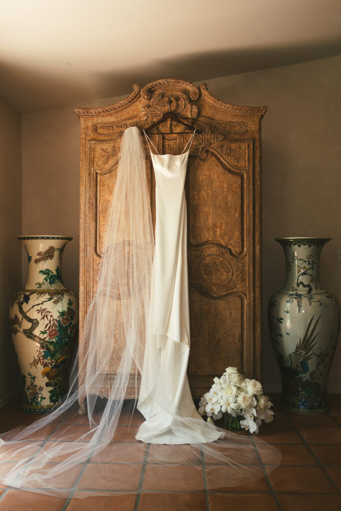 wedding dress and veil detail photo on an ornate wardrobe