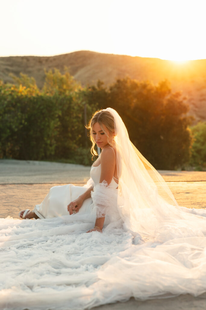 bride sits on wedding cape