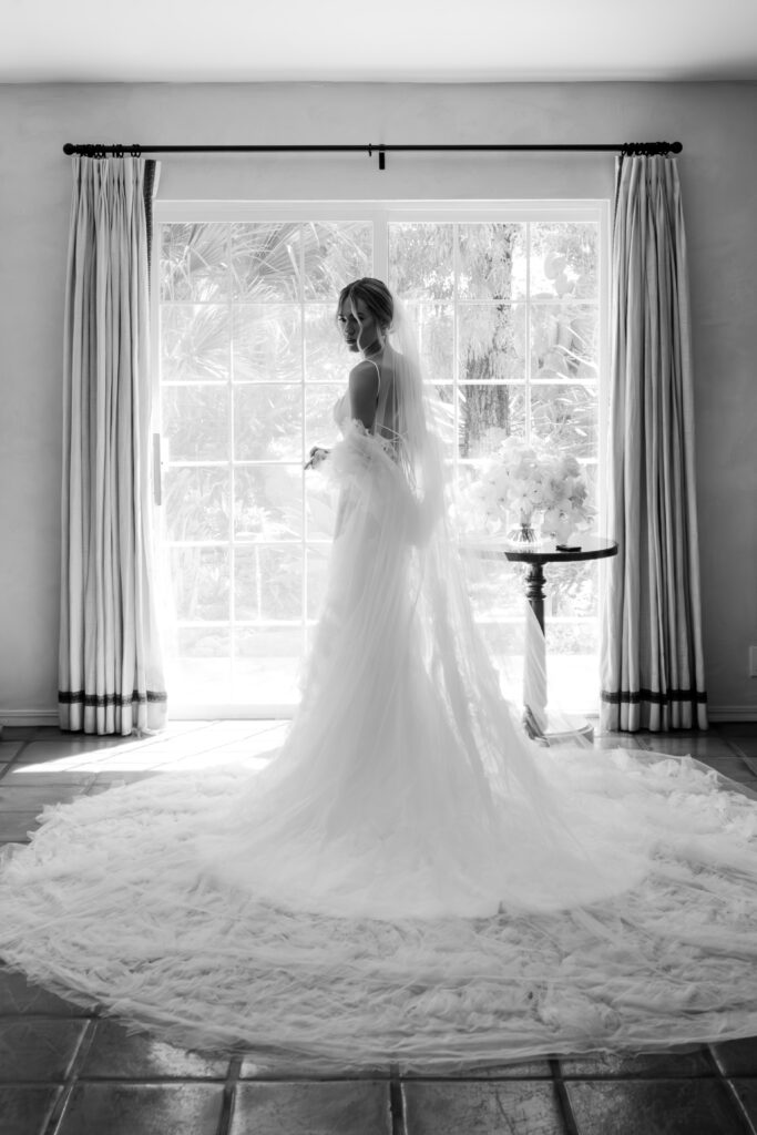 bride stands with white wedding cape