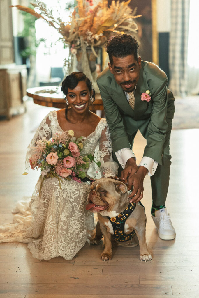 couple poses with dog at wedding