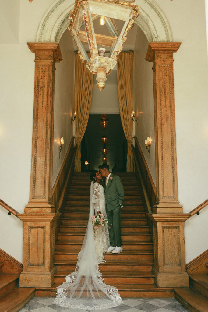 couples kisses on long staircase at Hotel Peter and Paul New Orleans wedding