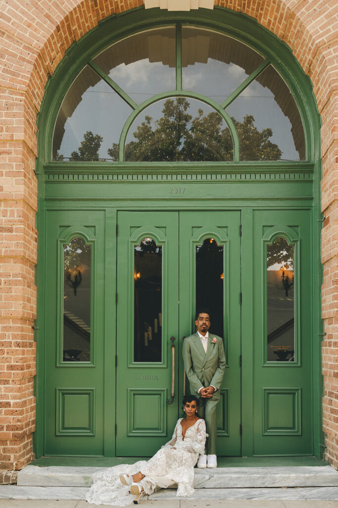 couple poses in front of green door at Hotel Peter and Paul New Orleans wedding