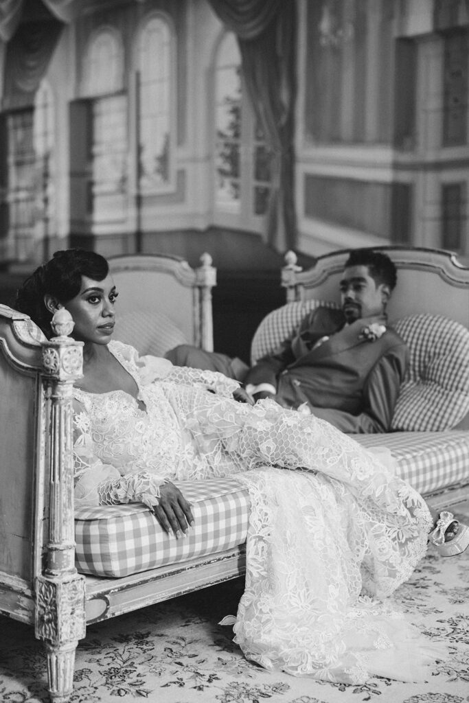 couple poses on couches at Hotel Peter and Paul New Orleans wedding