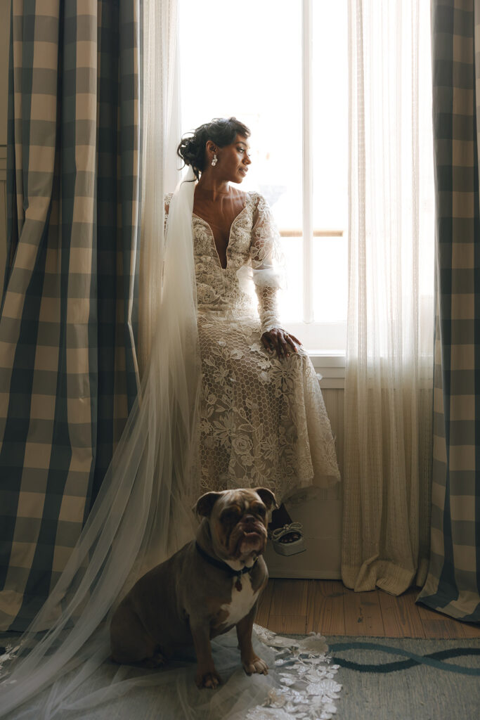 couple sits on window with dog at Hotel Peter and Paul New Orleans wedding
