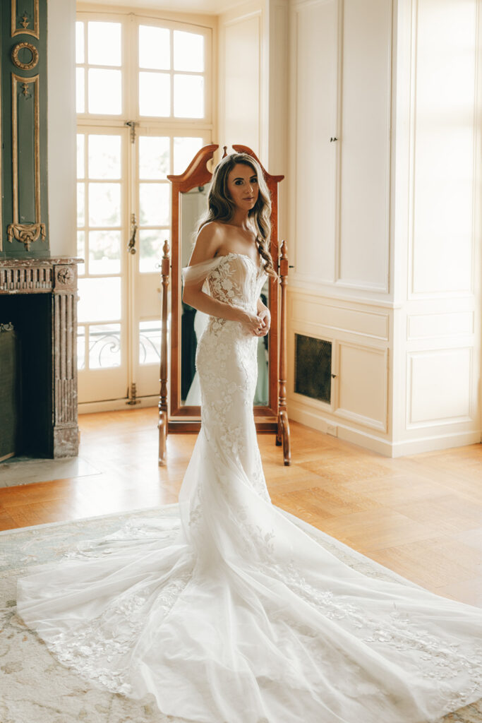 bride stands in front of mirror wearing wedding dress