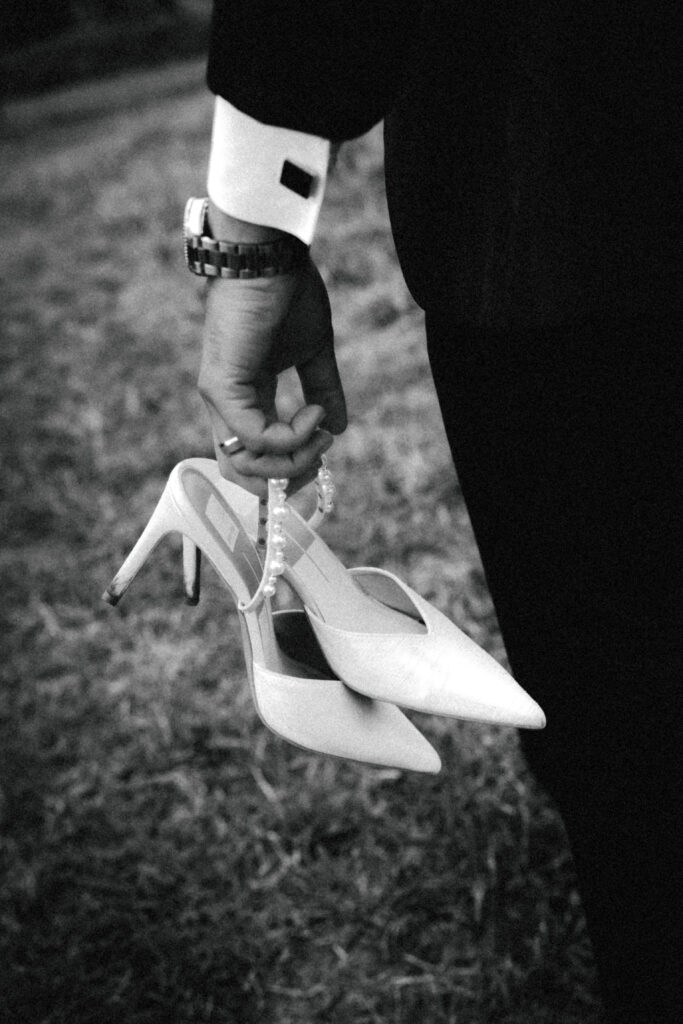 groom holding bride's pearl shoes