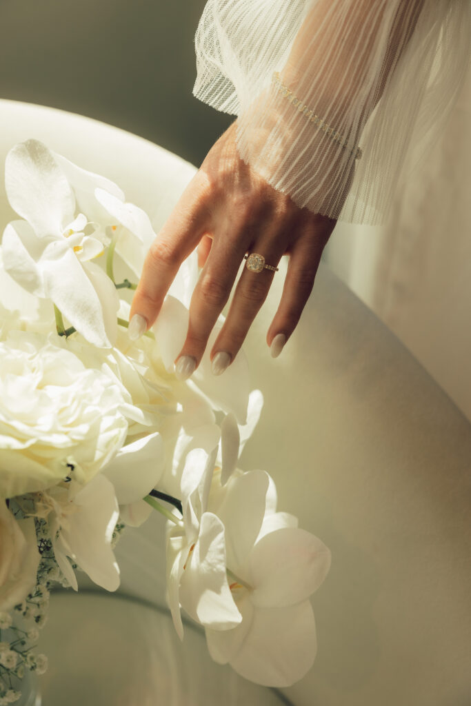 bride hand with engagement ring and orchids