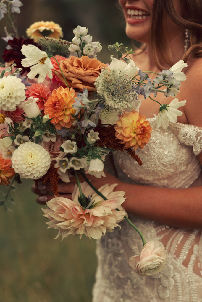bride holds wildflower boho wedding bouquet 