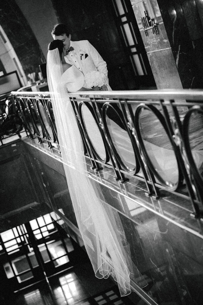 couple kisses over balcony at hotel wedding venue