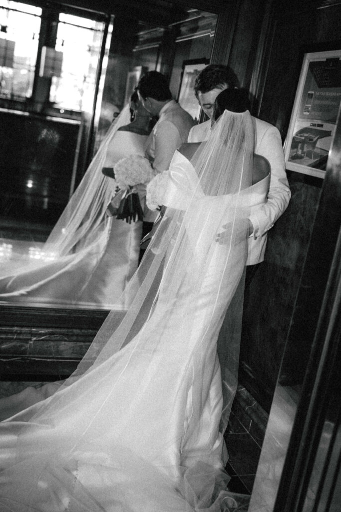 bride and groom kissing with reflection in mirror