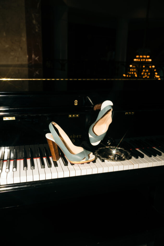 bride's blue shoes on piano with other wedding details