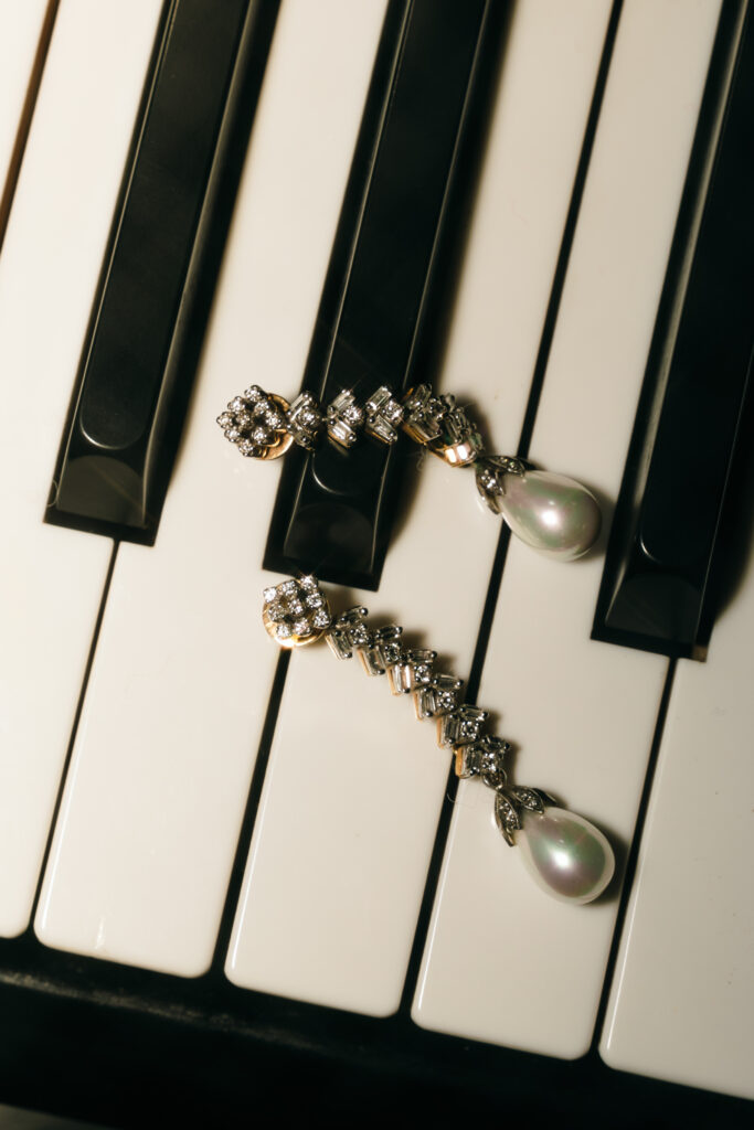detail shot of earrings laid on piano 