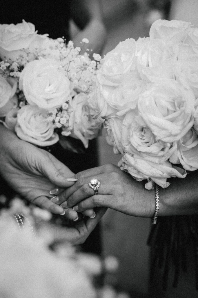 bride's hand held by bridesmaids showcasing her ring and all the bridal bouquets surrounding it