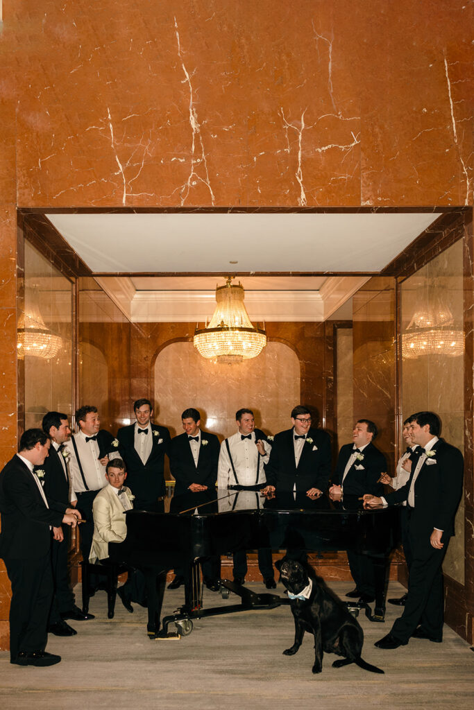 groomsmen gather around groom at hotel wedding venue