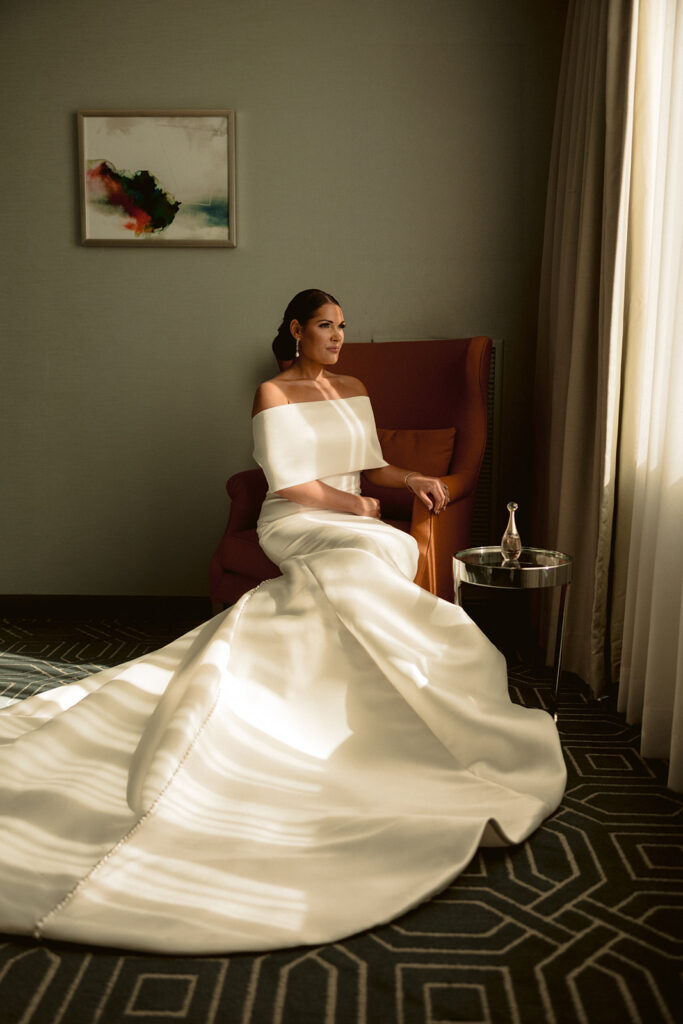 bride looking through window at hotel wedding venue