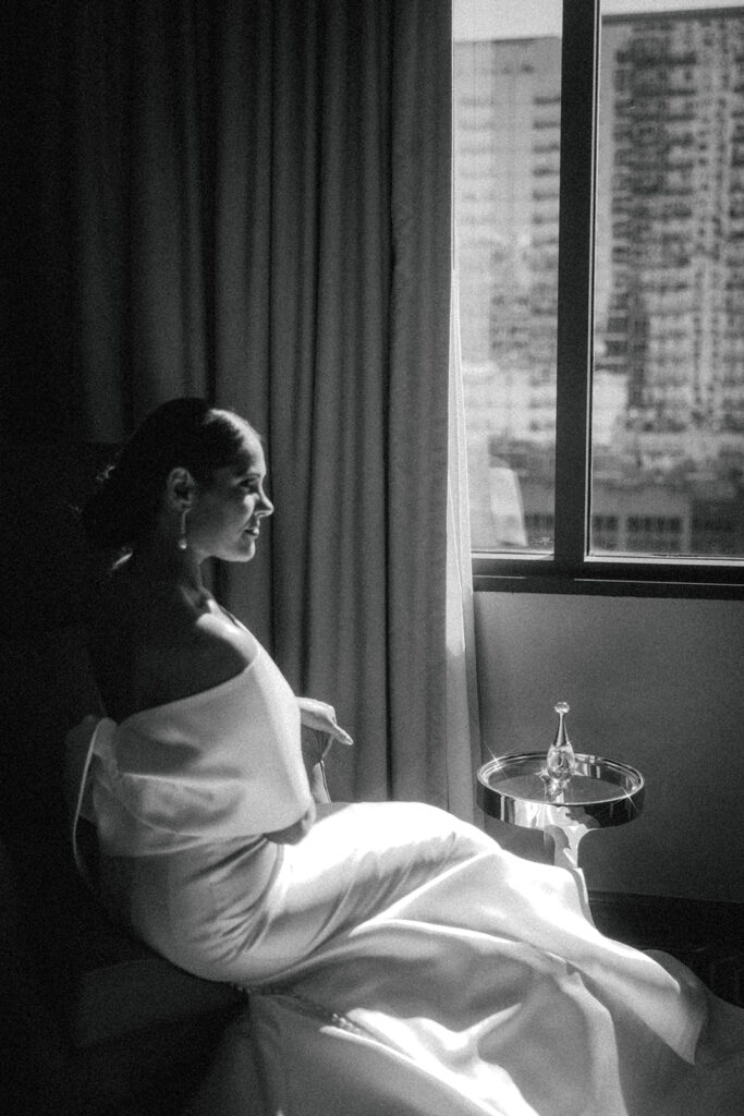 bride looking through window at hotel wedding venue