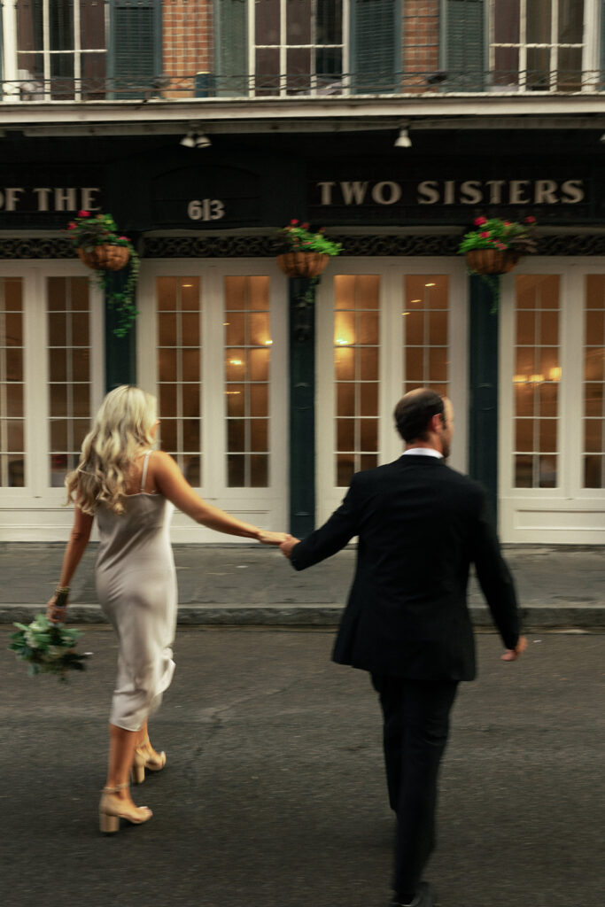 couple holds hands on the streets of New Orleans at engagement session