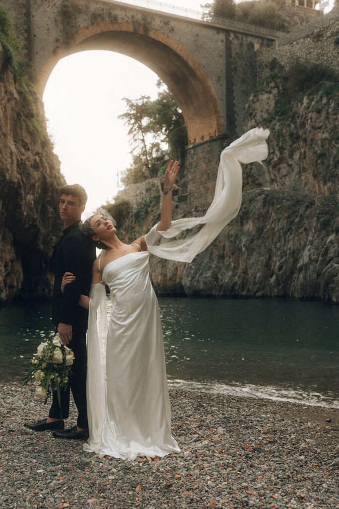 couple blows dress in the wind at Amalfi coast sunset elopement