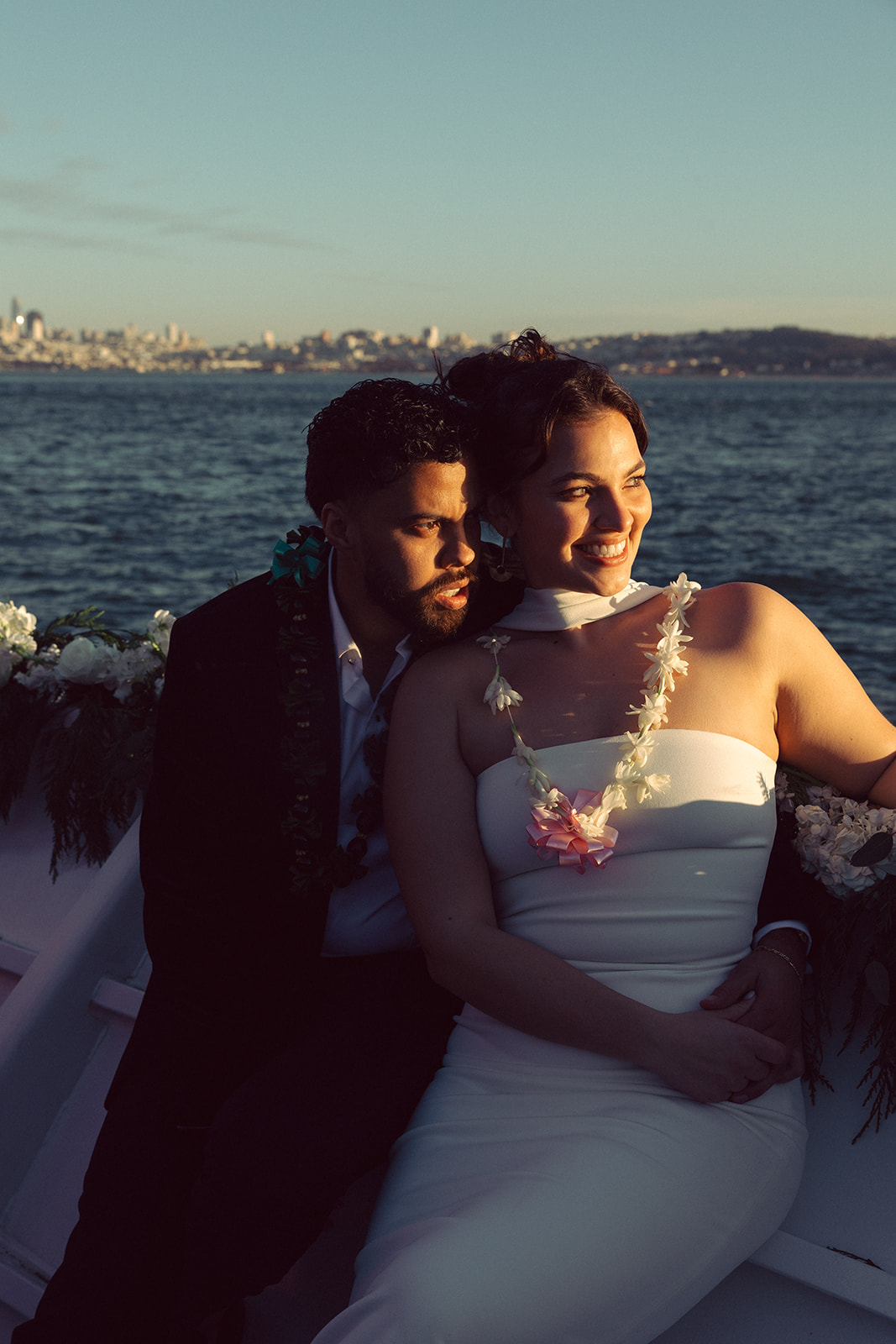 couple embraces on boat at sunset San Francisco elopement