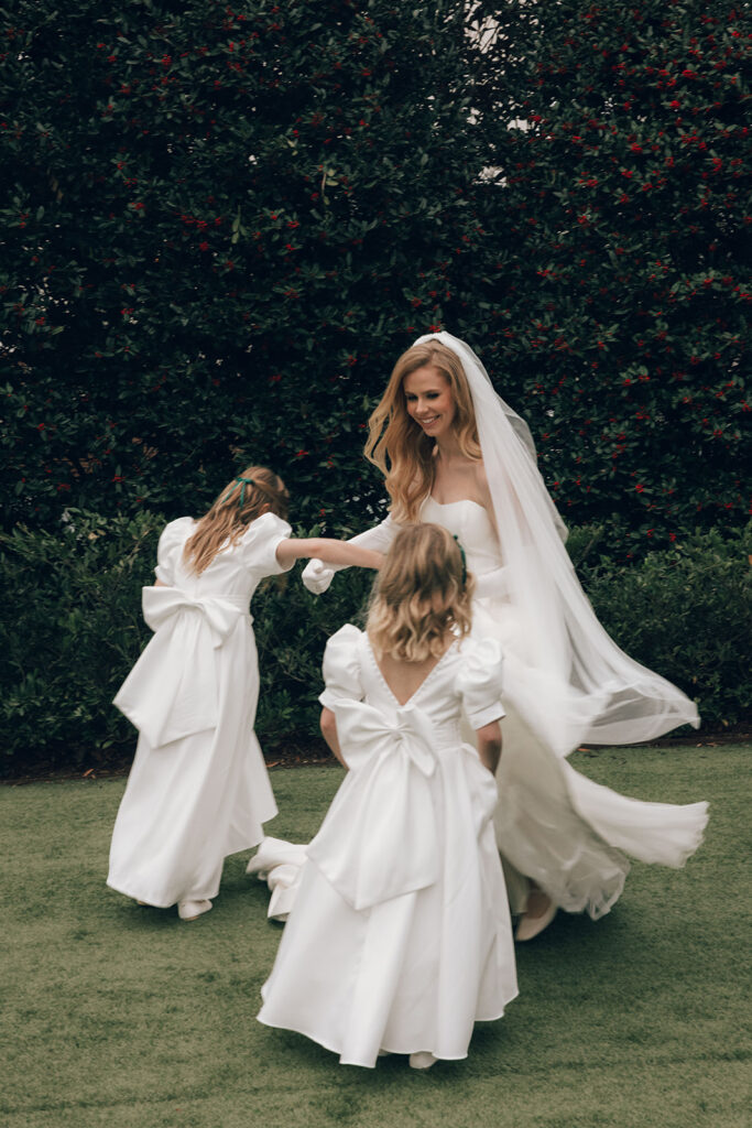 bride twirls with flowers girls in white dresses 