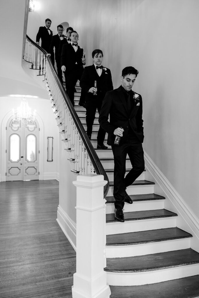 groomsmen walk down staircase at The Merrimon-Wynne House