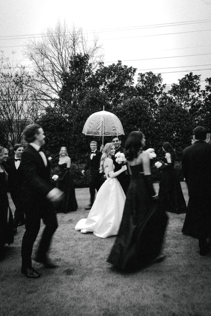 wedding party walks around couple in center of circle at The Merrimon-Wynne House