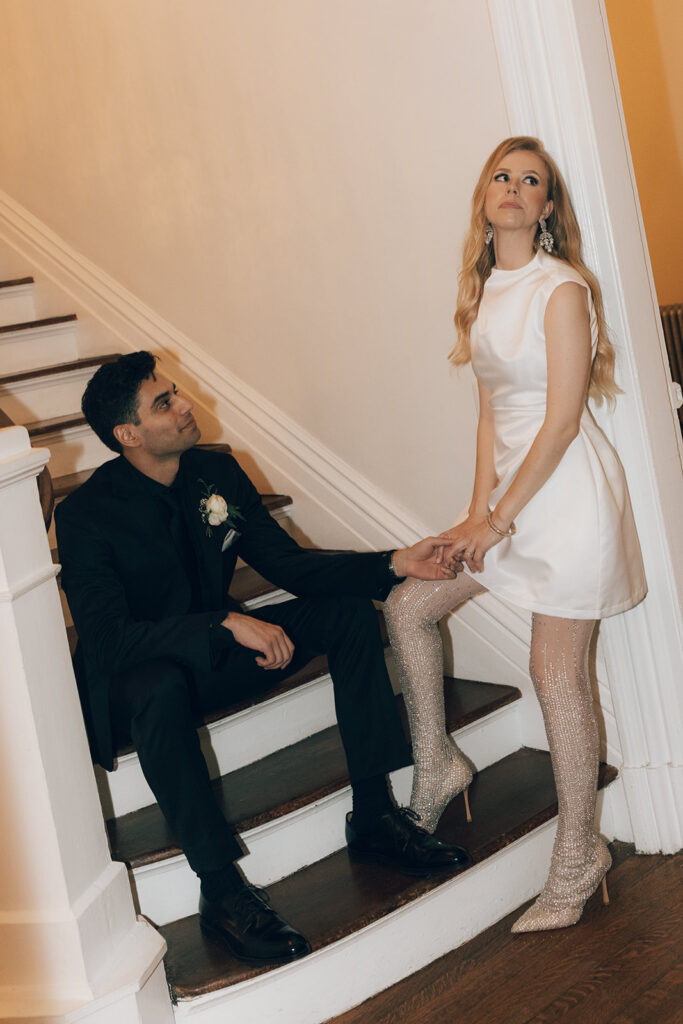 couple poses together on staircase at The Merrimon-Wynne House