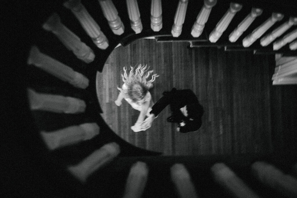 couple twirls under staircase at The Merrimon-Wynne House