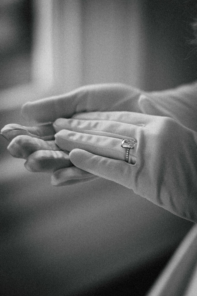 bride wears ring over silk wedding gloves 