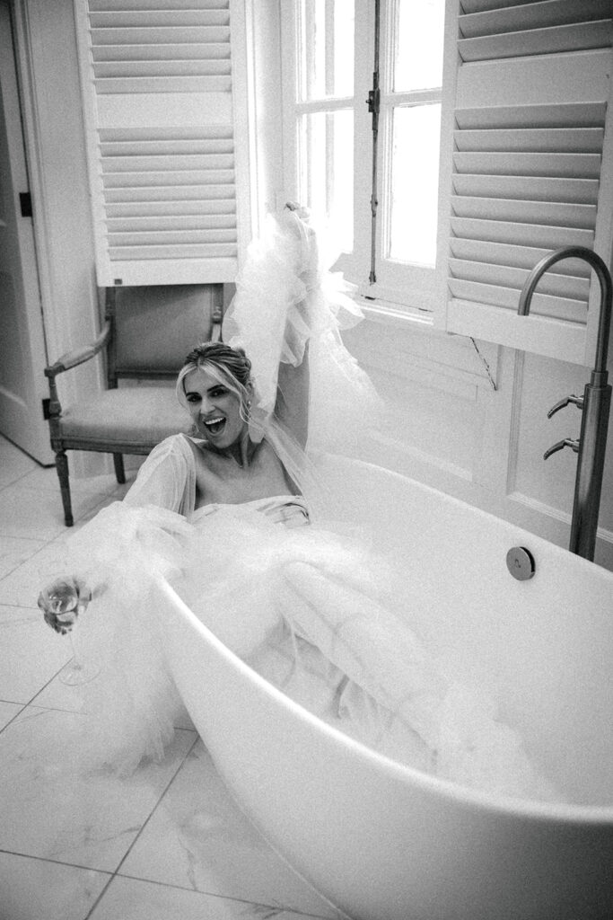 bride poses in bathtub in wedding dress 