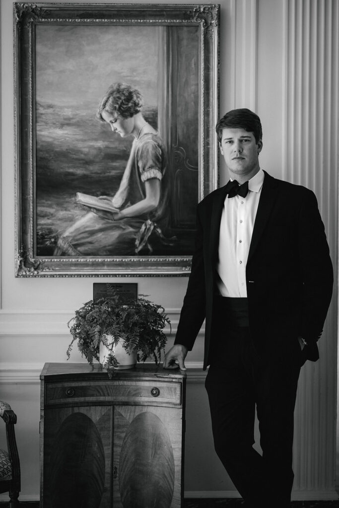 groom poses beside painting at The Duke Mansion Charlotte